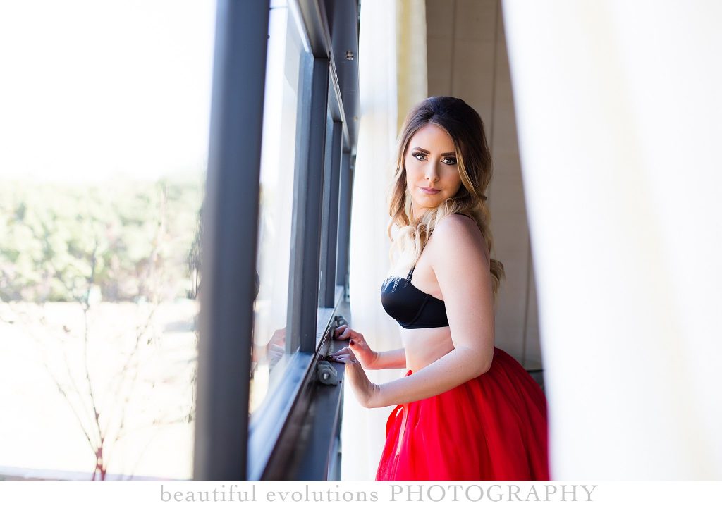 boudoir session in window with red tulle skirt