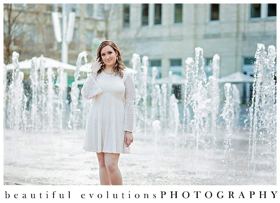 Girl in white dress in front of fountains