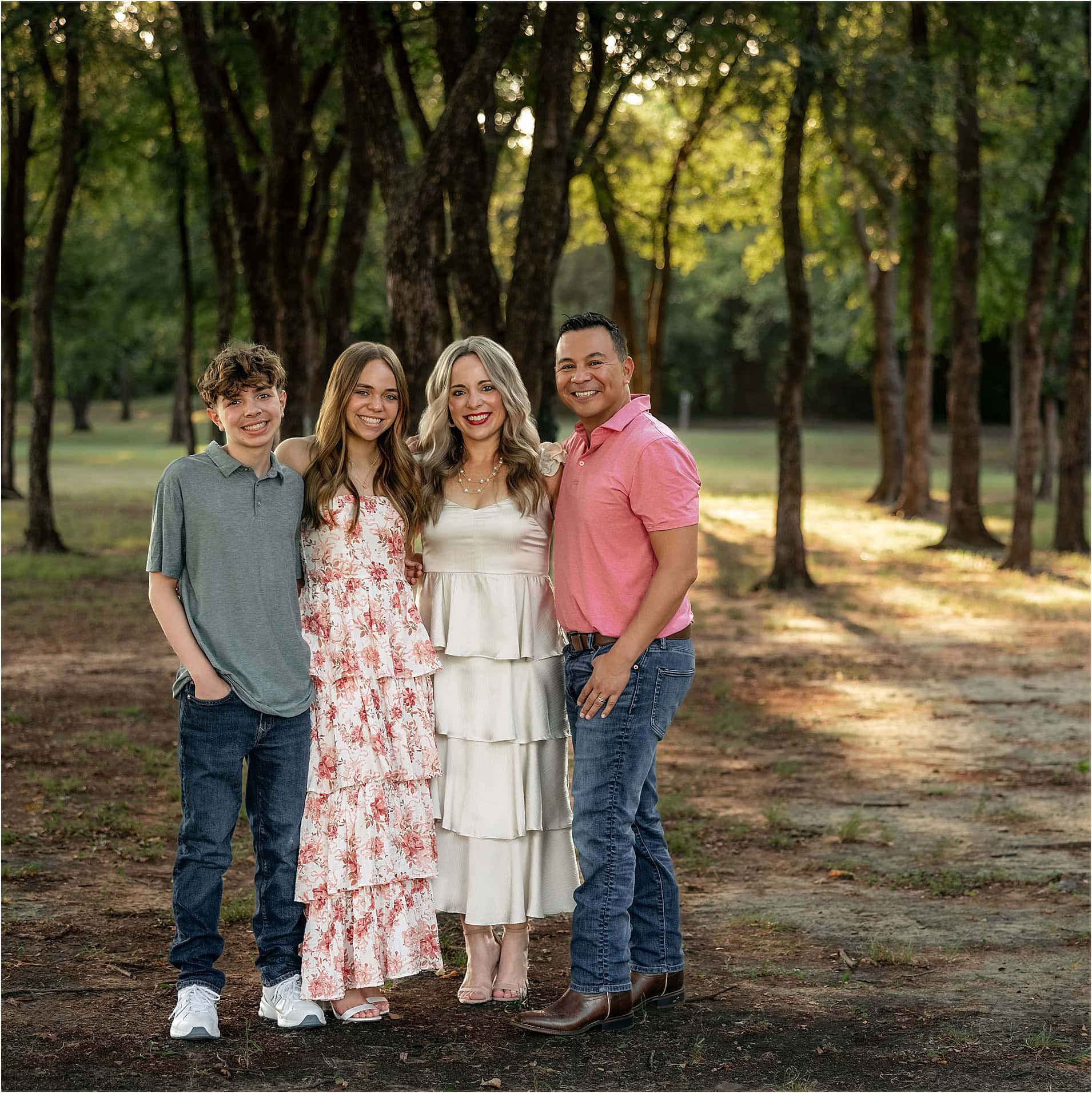 A family poses for a photo in the park.